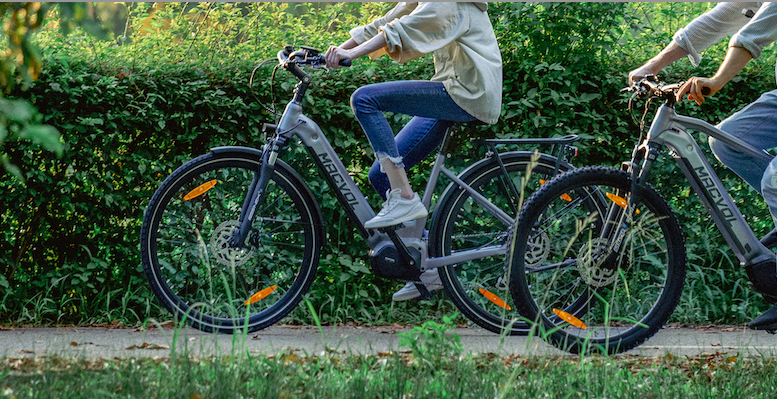 Two people riding together on macvol's e-bike